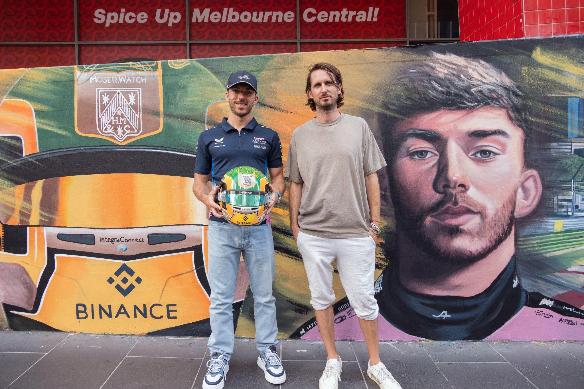 Pierre Gasly segura o capacete desenhado pelo fã Tiago Barra para o GP da Austrália, ao lado de Matt Adnat, que pintou mural dedicado ao piloto em Melbourne (foto divulgação)